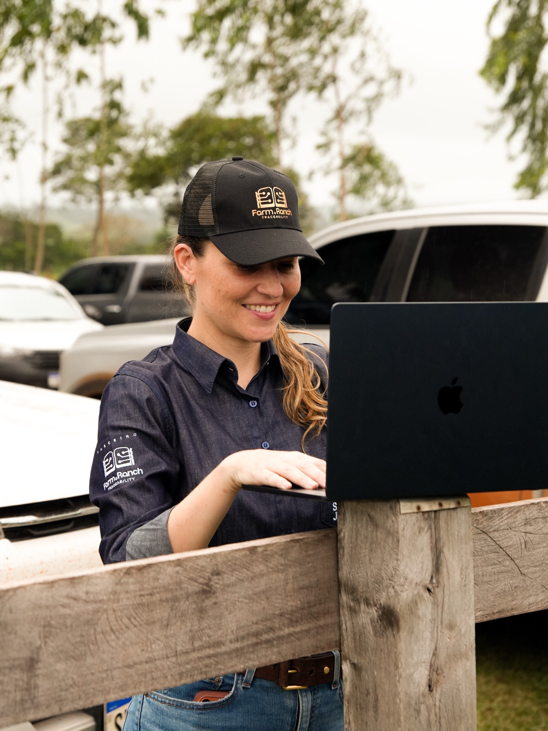 Funcionária Farm & Ranch usando notebook no campo